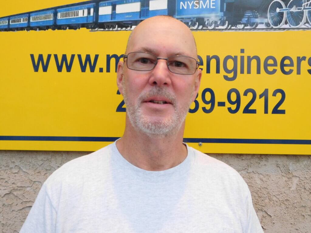 Club member with glasses in front of the clubhouse sign